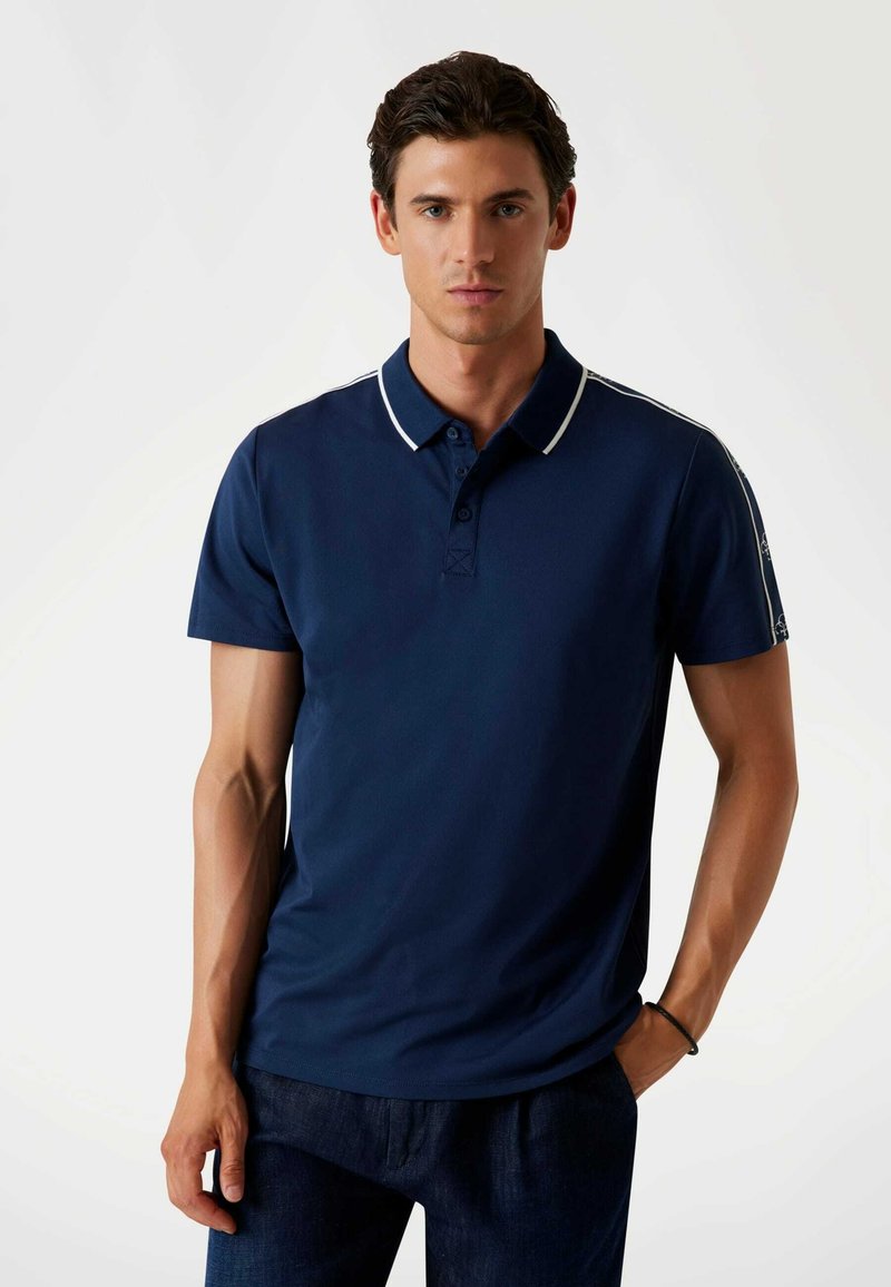 Marineblaues Poloshirt aus glattem Stoff, mit klassischem Kragen, Dreiknopf-Leiste und weißem Besatz an Kragen und Schultern.