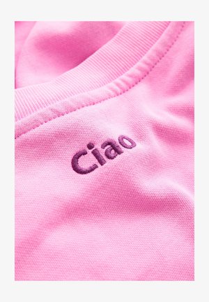 Tessuto rosa con cuciture strutturate, con la parola "Ciao" ricamata in una tonalità più scura di viola, posizionata vicino allo scollo.