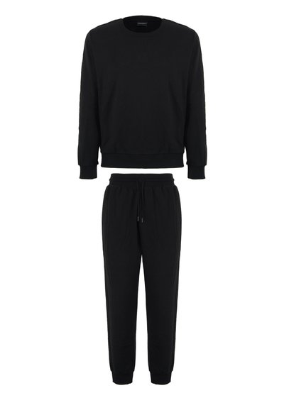 Felpa in cotone nera con maniche lunghe e collo rotondo, abbinata a pantaloni tuta con coulisse e caviglie affusolate.