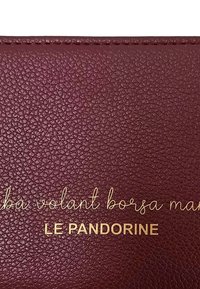 Portafoglio in pelle martellata bordeaux con testo in rilievo dorato "LE PANDORINE" e "maba volant borsa mar" sulla superficie.