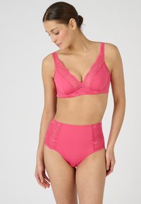 Conjunto de lencería rosa que incluye un bralette de escote en V profundo con encaje y una braga de tiroalto con acentos de encaje en los laterales. Textura suave.