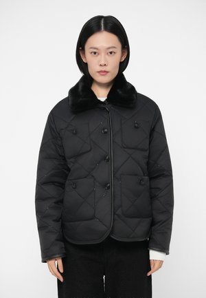 Veste noire matelassée avec un col en fausse fourrure, fermeture à boutons et deux poches avant avec un motif en losanges sur tout le tissu.