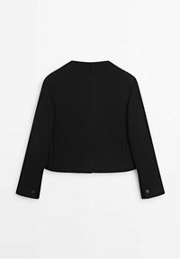Veste noire courte à manches longues avec un col rond, une couture simple au dos et des poignets boutonnés, posée à plat sur un fond blanc.