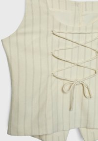 Top con cordones hecho de tela beige con finas rayas verticales. Cuenta con un diseño frontal de cordones y un cuello redondeado.