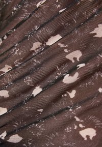 Tejido marrón translúcido con un patrón floral que presenta acentos de colores claros. La textura es suave y ligeramente arrugada.