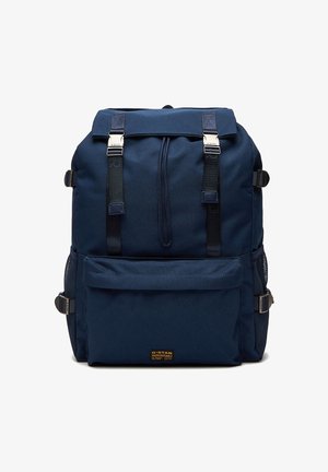 Marineblauer Rucksack mit vordere Reißverschlusstasche, zwei schwarzen Gurtverschlüssen, Netzseitentaschen und oberem Kordelzugverschluss.