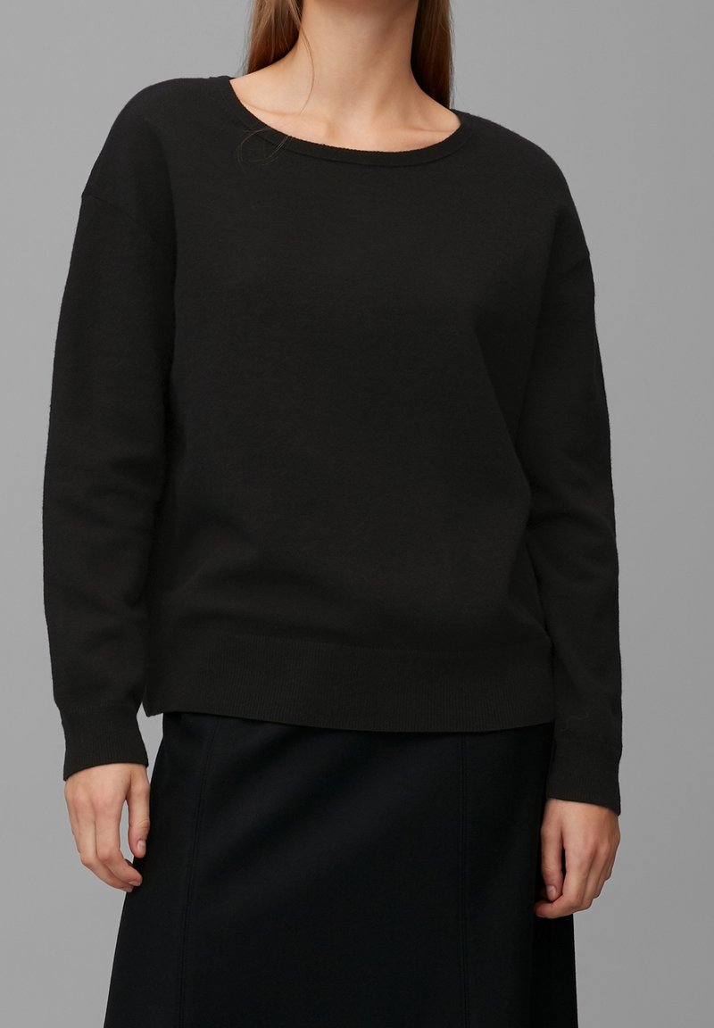 Schwarzer Pullover mit rundem Ausschnitt, langen Ärmeln und gerippten Bündchen. Hergestellt aus einem weichen Material und mit einem lässigen Schnitt. Eignet sich gut zum Schichten.