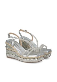Zilveren wedge sandalen met kruislingse banden, geweven textuurdetails en decoratieve kralen langs de zool. Zachte voetbed en open teen ontwerp.