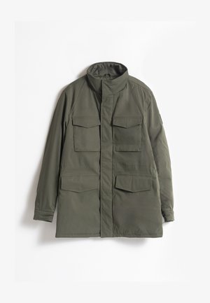 Parka de color verde oliva con un collar alto, dos bolsillos en el pecho y grandes bolsillos frontales. Tela suave y diseño de corte recto.