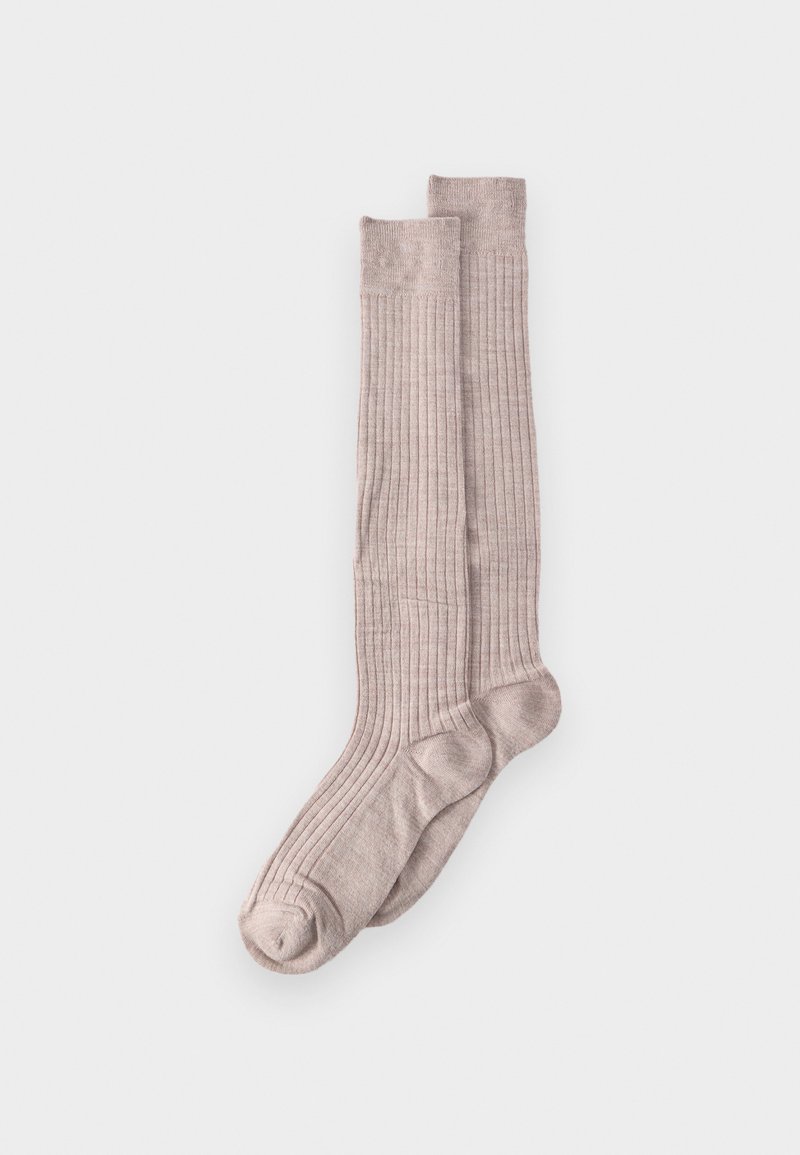 Ζεύγος μπεζ κάλτσες ριπ μέχρι το γόνατο, απλωμένες επίπεδες σε λευκό φόντο.