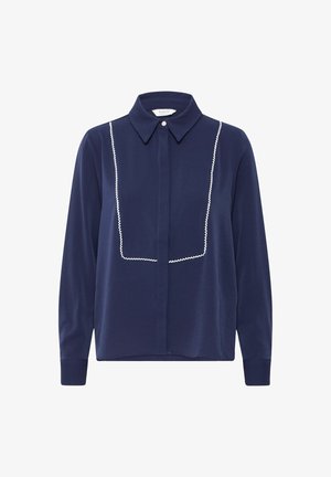 Camisa de manga larga azul marino con cuello clásico, con acentos bordados en blanco a lo largo del panel delantero y cierre de botones.