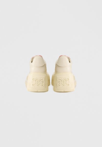 Κρεμ πλατφόρμα αθλητικά παπούτσια με ανάγλυφη κίτρινη σόλα, διαθέτουν ροζ λεπτομέρεια στη φτέρνα και λείο δερμάτινο επάνω μέρος.