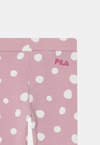 Leggings rosa con macchie astratte bianche, con un logo Fila in gradiente di colori. Realizzati in tessuto morbido ed elastico.