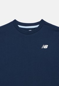 Navy blue crew neck t-shirt with small white New Balance logo on left chest.