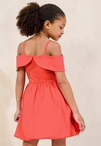 Vestito di corallo con design off-shoulder, corpino aderente e gonna svasata. Tessuto liscio, vita arricciata e dettaglio del bottone sul retro discreto.