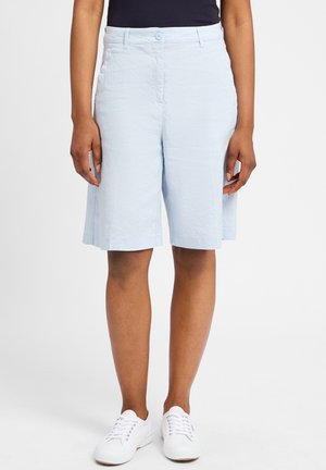 Lichtblauwe shorts gemaakt van textiel met een gestructureerde stof, met een tailleband en knoopsluiting, reikend net boven de knie, gecombineerd met witte sneakers.