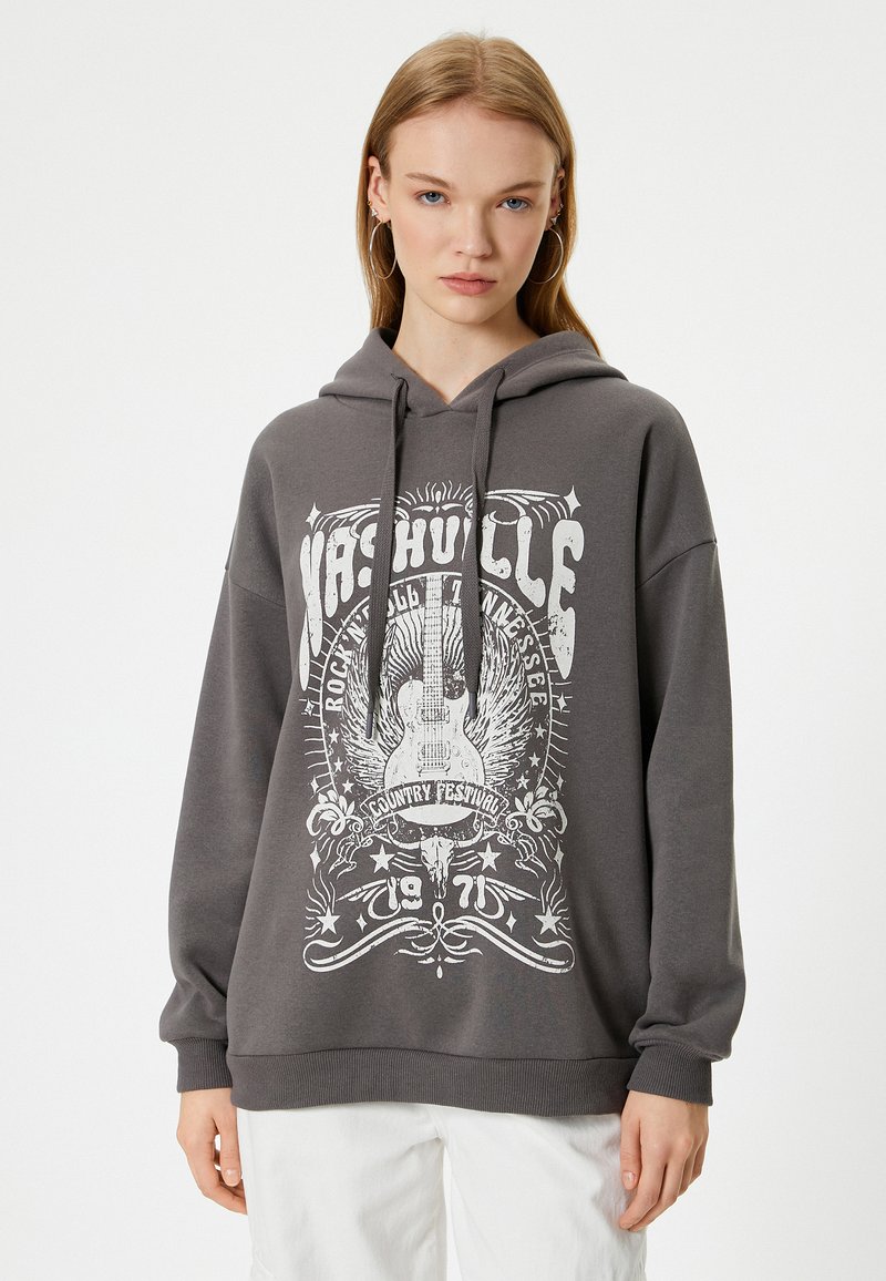Grijze hoodie met een witte afdruk van een gitaar en sterren. Ontspannen pasvorm, capuchon met trekkoord en ribgebreide manchetten. Zachte katoenmix.