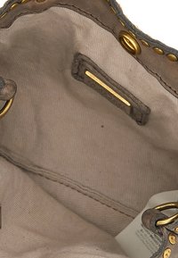 Interno di una borsa in pelle color cuoio con dettagli in metallo dorato. Presenta una fodera in tessuto morbido, una tasca laterale e cuciture visibili.