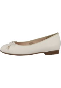 Ballerines en simili cuir beige avec un bout rond, un nœud décoratif et un accent en perle. Présentent un petit talon et une semelle marron contrastante.
