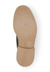 Parte inferior de zapato negro con una suela de goma beige texturizada. Presenta una cremallera lateral y un tacón liso y curvado.