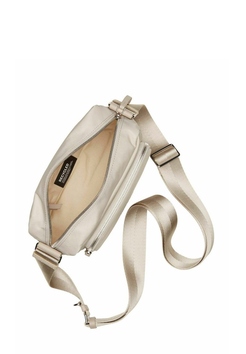 Beżowa torebka na ramię o prostokątnym kształcie, z zamknięciem na zamek błyskawiczny i gładką fakturą. Regulowany tekstylny pasek z metalowymi elementami.