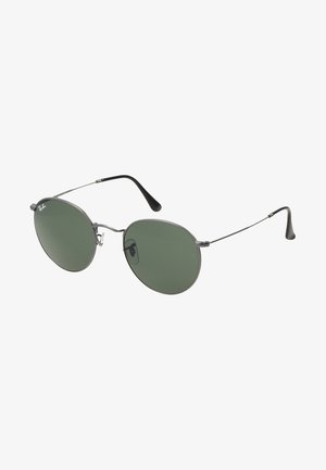 Lunettes de soleil en métal avec des verres ovales verts. Monture en métal argenté mince et embouts d'oreille noirs. Design minimaliste, sans logos visibles.