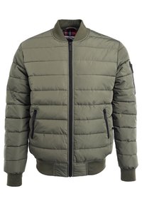 Chaqueta bomber acolchada color verde oliva con cierre frontal, puños acanalados y dos bolsillos laterales; cuenta con un forro de cuadros visible en el cuello.