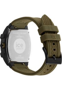 Reloj con correa de silicona verde, caja negra, fondo de acero inoxidable y acentos texturizados. Presenta una forma redonda y un movimiento Miyota.