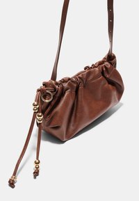 Borsa a tracolla in pelle marrone con design arricciato, dettagli in hardware dorato e chiusura con cordoncino. Tracolla regolabile per un uso versatile.