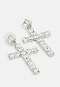 Boucles d'oreilles en croix argentées ornées de strass clairs, avec une finition lisse et brillante et un fermoir sécurisé.