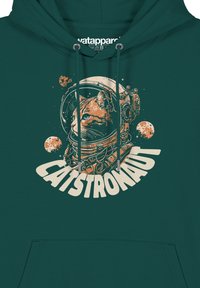 Teal hoodie met een grafisch ontwerp van een oranje kat in een astronautenhelm, met ruimte-elementen en de tekst "CATSTRONAUT" eronder.
