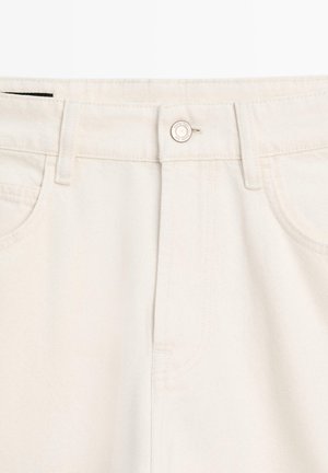 Beige denim jeans featuring a button closure, front pockets, and a smooth texture. The fabric appears sturdy with a classic five-pocket design.