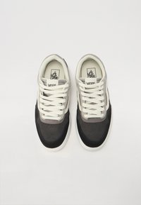 Vans sneakers featuring a gray and black suede upper, white laces, round toe, and a white rubber sole. Branding visible on the tongue.