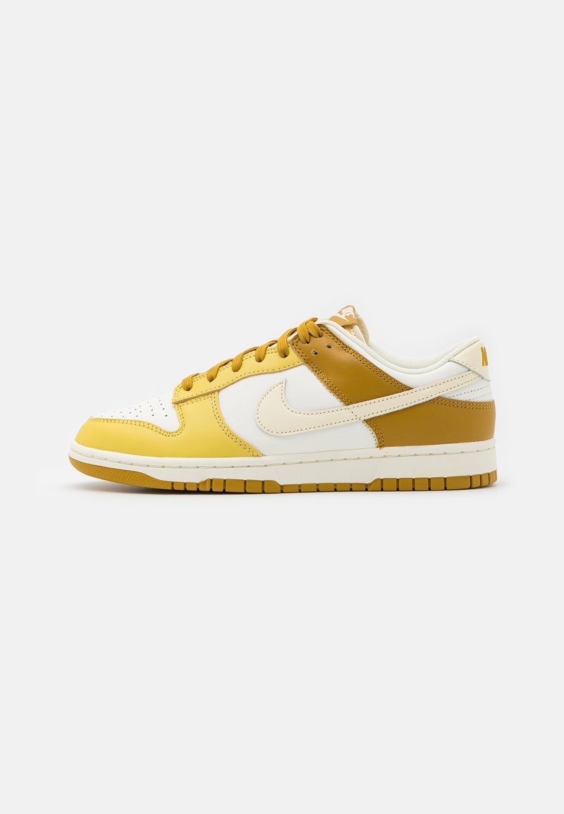 Baskets basses en cuir blanc, jaune moutarde et beige, avec des lacets beiges et une semelle en caoutchouc, vues de profil sur un fond blanc.