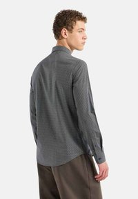 Camicia grigia a fantasia con vestibilità slim, dotata di un colletto piccolo e polsini con bottoni, realizzata in un tessuto liscio, mostrata da una vista dorsale.