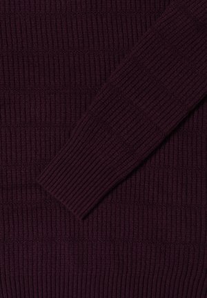 Pull en maille côtelée de couleur violet foncé avec des motifs de texture verticaux et horizontaux bien marqués. Présente une manches coupée en biais avec un ajustement près du corps.