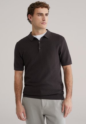 Donker polohemd met textuur, een kraag, korte mouwen en een knoopsluiting met drie knopen, gecombineerd met lichtgrijze broek.