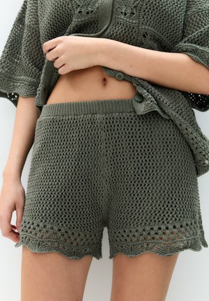 Khaki háčkované kraťasy s texturovaným vzorem, vlněným lemem a elastickým pasem. Styling s odpovídajícím otevřeným pleteným topem.
