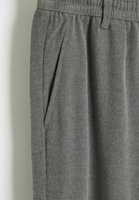 Szare materiałowe spodnie z elastycznym pasem, z detalem w formie zakładki i bocznymi kieszeniami. Miękka struktura z casualowym designem.