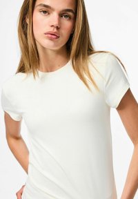 Balts īsām piedurknēm T-krekls, izgatavots no mīkstas, gludas auduma ar apaļu kakla izgriezumu. Vienkāršs dizains ar pieguļošu siluetu.