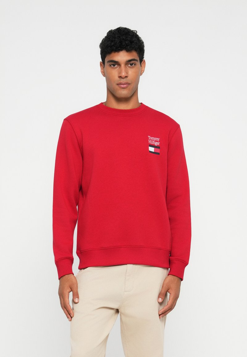 Sweatshirt rouge en mélange de coton, avec un col rond côtelé, des manches longues et un petit logo brodé avec des accents bleu marine et blanc.