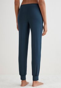 Türkise Jogginghosen mit schmalem Schnitt, aus weichem Material gefertigt, mit elastischen Bündchen und einem glatten Bund. Keine sichtbaren Nähte oder Taschen.