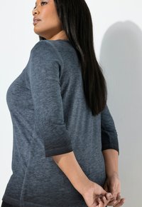 Szary top z długim rękawem o subtelnym gradientowym wzorze, zaokrąglonym dekoltem i rękawami do łokcia, pokazany z boku.