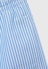 Modra in bela črtasta tkanina, izdelana iz teksturirane mešanice bombaža, oblikovana v ravnem kroju z detajlom stranske žepa.