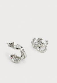 Cercei din argint cu un design spiralat, având un finisaj neted și un sistem de prindere sigur cu tijă. Detalii notabile includ un model subtil în interior.