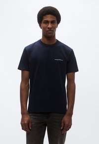 Tengerészkék pamut póló kerek nyakkivágással és rövid ujjal, bal oldalon a mellrészen kis fehér hímzett logóval.