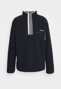 Pullover in pile nero con colletto alto, patta con bottoni grigia e tasca sul petto con zip. Presenta accenti bianchi a contrasto.