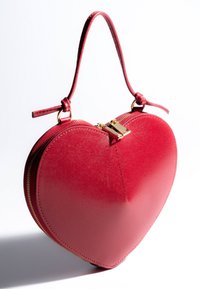 Red leather heart-shaped handbag with gold zipper and short handle, shown against a white background.