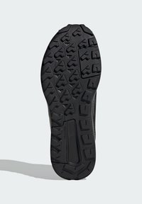Semelle en caoutchouc noir avec des motifs géométriques profonds, conçue pour offrir une adhérence optimale. Dispose d'une surface texturée pour un meilleur grip et une durabilité accrue.