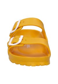 Yellow strap sandal made of smooth material. Features two white adjustable buckles and a textured sole for grip.